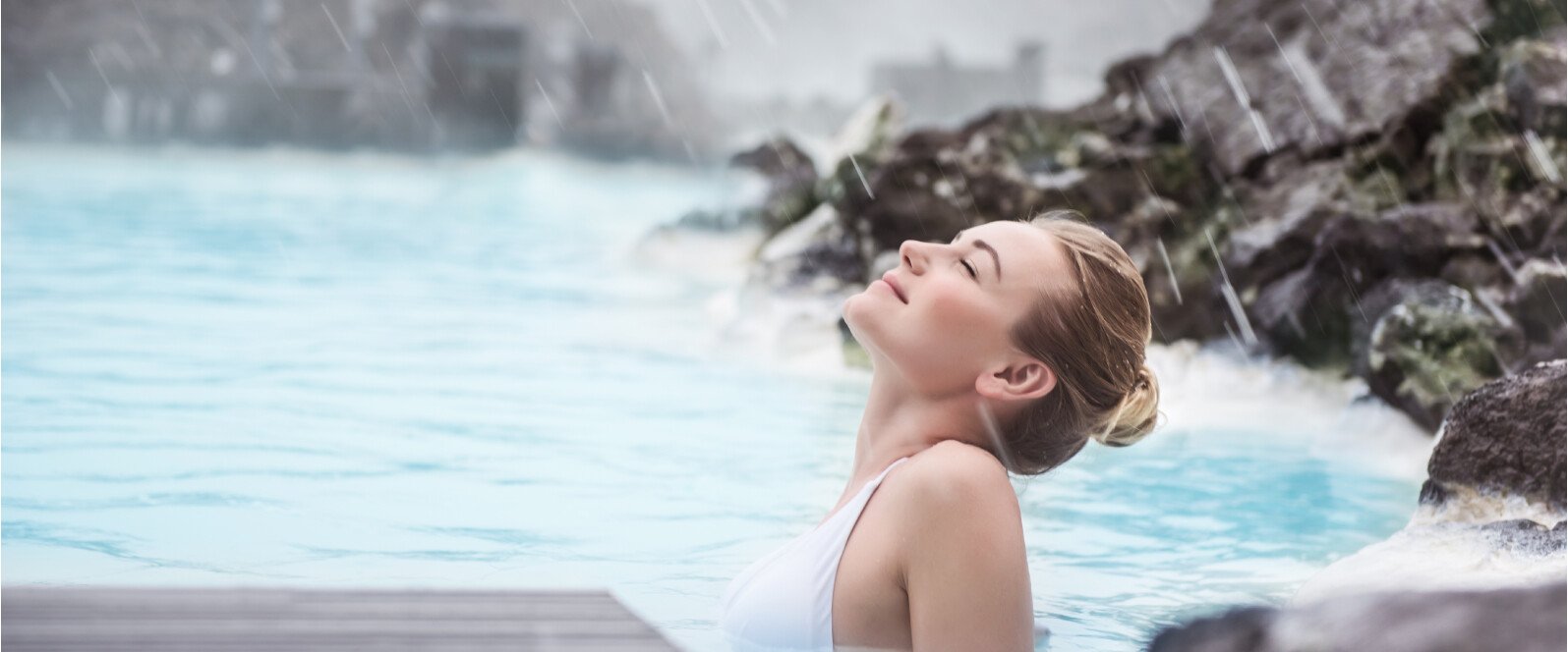 Eine junge Frau badet in einer Thermalquelle und genießt den Moment